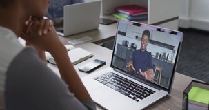 Mid section of african american woman having a video call on laptop with female colleague at office. business, professionalism and technology concept