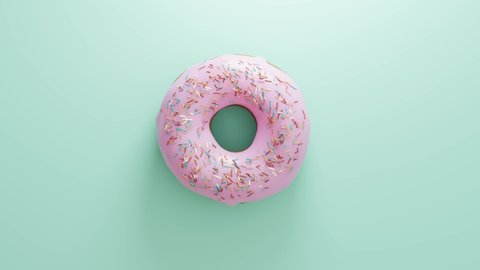 Colorful sprinkled pink icing donut doughnut spinning in on mint green background 60fps smooth