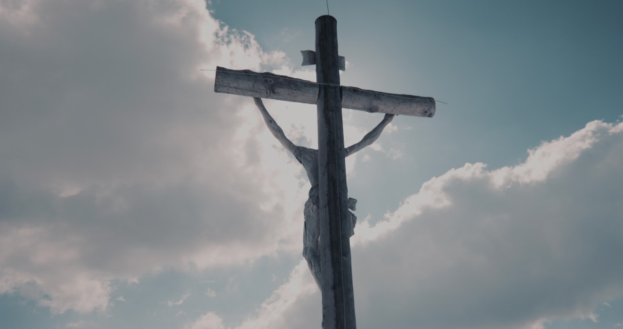Wooden Holy Cross illuminated by sun on sky background, Jesus Christ crucified Royalty-Free Stock Footage #1073072033