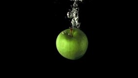 Super slow motion one green apple falls under the water. On a black background. Filmed on a high-speed camera at 1000 fps. High quality FullHD footage - Powered by Shutterstock - Get 15% off with code: PIKWIZARD15
