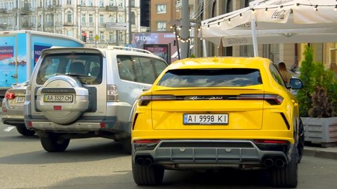 Kiev, Ukraine - May 22, 2021: Yellow luxury super SUV Lamborghini Urus parked in the city. Lamborghini Urus SSUV in the city