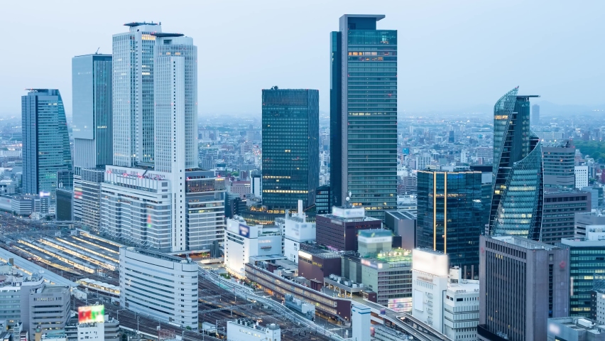 Time lapse movie of modern city and trains twilight view. Rail traffic. Zoom out.