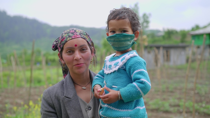 
Close shot of a young Indian Pahari woman or female in a traditional dress standing outdoors with a little child in her arms whose face is covered with a handmade face mask amid covid 19
 Royalty-Free Stock Footage #1073090204