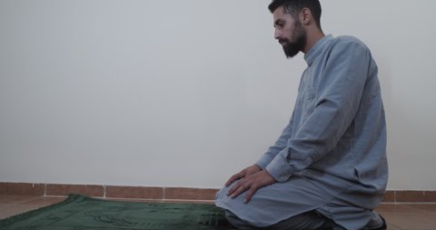 Zooming in on a Muslim man bowing down in prayer in slow motion