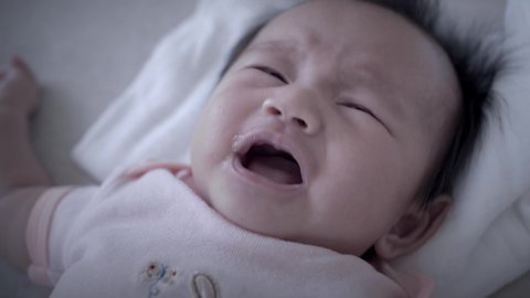Newborn baby unhappy, hiccups and crying (close-up)