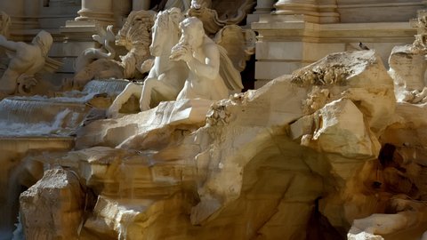 Streams of water flow into the bowl of the Trevi Fountain forcing his sculptures to come to life. Rome Italy