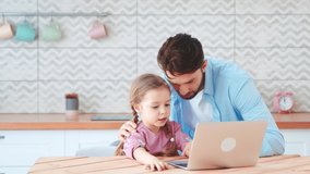 Young dad and little daughter talking on an online conference with mom using a laptop. Smiling dad and little daughter talking on an online conference