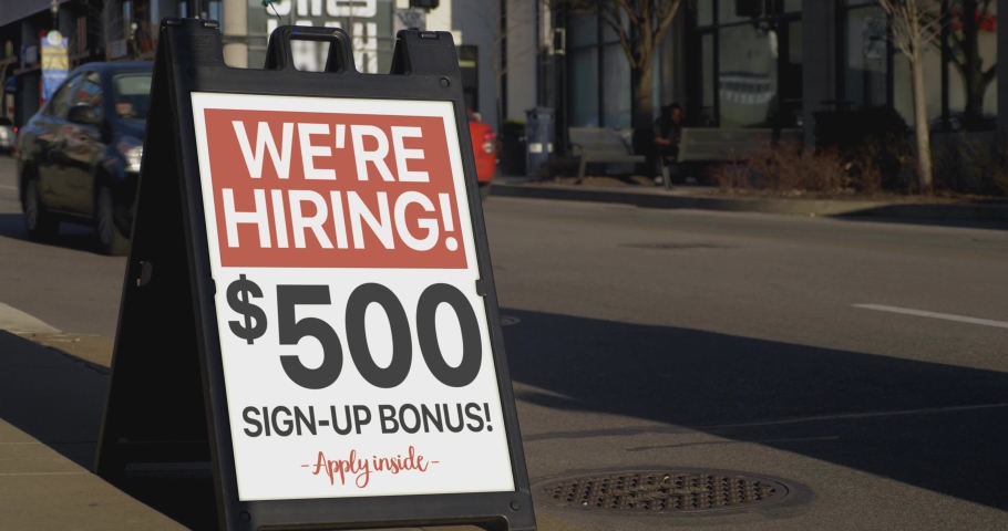 A "We're Hiring!" sandwich board sign outside of a business on a city sidewalk. Sign shows $500 sign-up bonus. Sign customizable upon request.	 Royalty-Free Stock Footage #1073104598