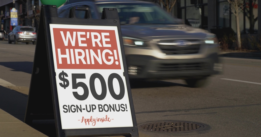 A "We're Hiring!" sandwich board sign outside of a business on a city sidewalk. Sign shows $500 sign-up bonus. Sign customizable upon request.	 Royalty-Free Stock Footage #1073104598