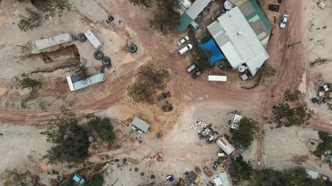 A high view looking down at a old pub and discarded mining equipment in the Australian outback of a small mining town in the opal capital of the world Lightning Ridge