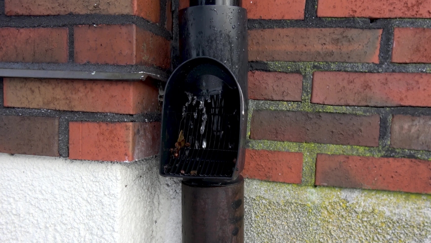 Downpipes on brick wall with water flowing through pipe with self-cleaning leaf filter. Royalty-Free Stock Footage #1073121593