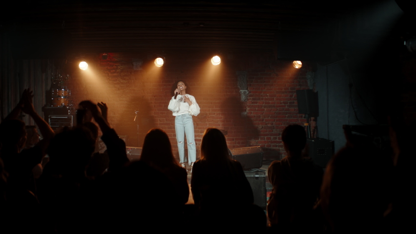 DOLLY Black African American young female comedian finishing her stand-up monologue and leaving stage of a small venue. Shot with ARRI Alexa Mini LF with 2x anamorphic lens | Shutterstock HD Video #1073129738