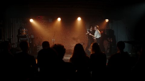 Young Caucasian male host of the stand-up show introducing female comedian and leaving stage. Shot with ARRI Alexa Mini LF with 2x anamorphic lens