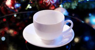 hot aromatic coffee is poured into a cup against a background of christmas bokeh