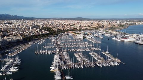 Boats anchored in marina of Palma de Mallorca in sunny day. Aerial forward
