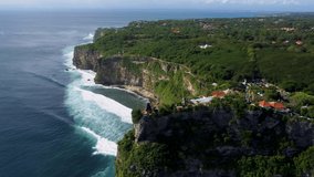 Fly along Uluwatu temple on the cliff over ocean in Bali Indonesia. High quality 4k aerial footage