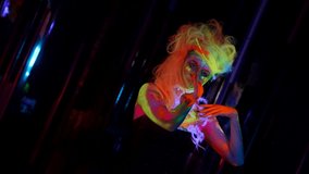 nightclub with ultraviolet light, woman with fluorescent makeup and body art, image for Halloween