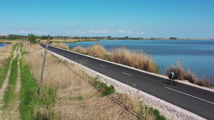 Bike packing cyclist on a beautiful road aside Razim lake in Dobrogea, Romania