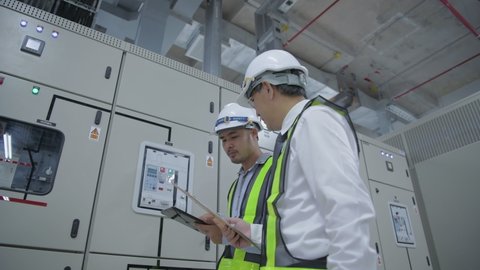 Business concept of 4k Resolution. Engineers inspecting electrical equipment controllers.