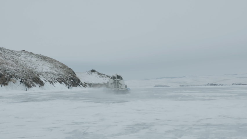 Hovercraft Khivus with a large fan transports tourists across the ice of frozen Lake Baikal to the islands