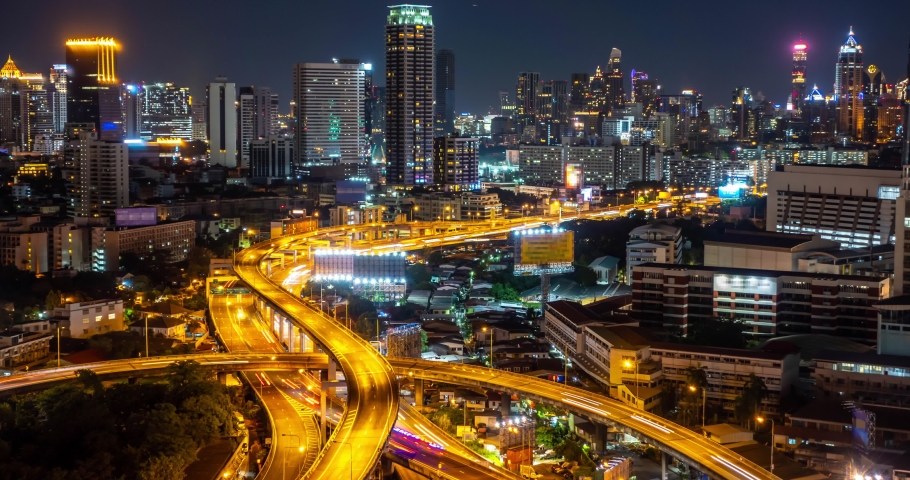 Time-lapse At Night,Of traffic on city streets at twilight, Timelapse of Bangkok Road roundabout with car Beautiful landmark in Business downtown in Thailand. Public transport Business District  Royalty-Free Stock Footage #1073154389
