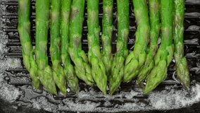 asparagus cooking on grill pan, top view. Healthy food concept. 4K UHD video