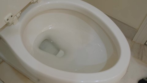 The water goes down the toilet .Close-up Slow motion