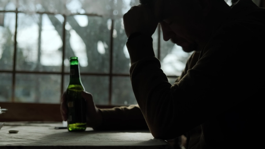 Close up of A man drinks alcohol alone, he thinks for a long time before drinking alcochol or beer.