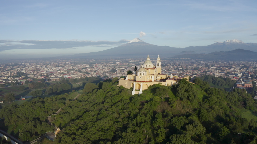 San Andres Cholula, Puebla, Mexico. July 02 of 2019. Our Lady of Remedies Church on the Great Pyramid of Cholula with Popocatepetl and Iztaccihuatl active volcanoes in the background.  | Shutterstock HD Video #1073174381