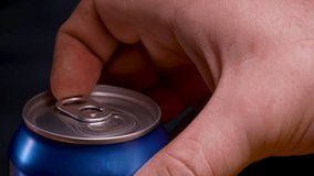 Opening a shaken can of beer, from which the foam flows. A detailed shot of a man's hand opening a stirred beer can against a black gradient background. Slow motion. Close up. - Powered by Shutterstock - Get 15% off with code: PIKWIZARD15