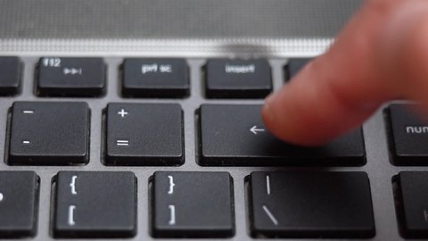 Backspace button pressing on keyboard, laptop keyboard close up