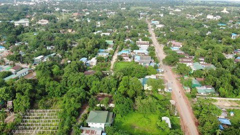 Drone flying over the streets of Bago in Myanmar. Motorists and bikers go about their daily lives in the green lush city