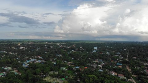 Drone flying over the historical city of Bago in Myanmar. People going about their daily life in rural Myanmar. Sunset view of the vast city skyline with natural beauty.