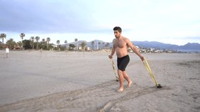 metabolic training on the beach with muscular man doing chest and rubber variant with kettlebell