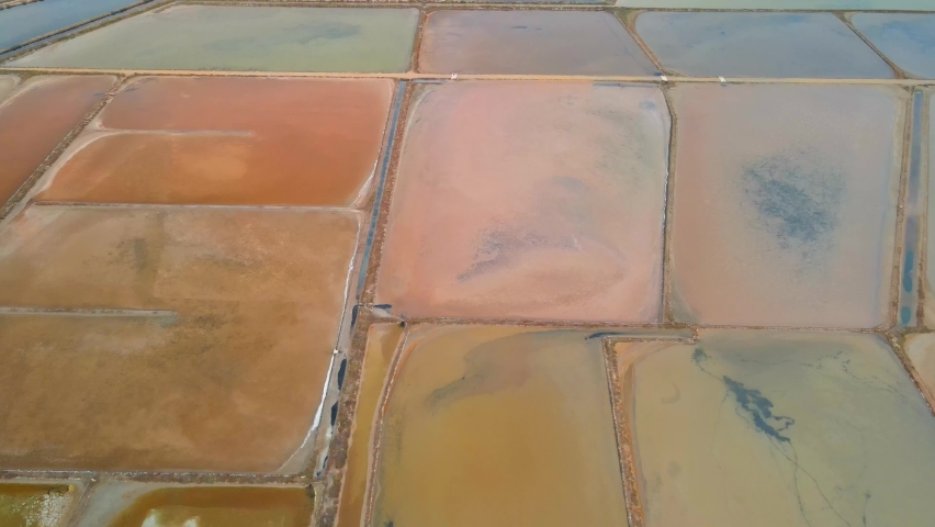 Drone shots in the Gruissan salt flats in France at sunrise. Pond with very bright colors, especially pink.