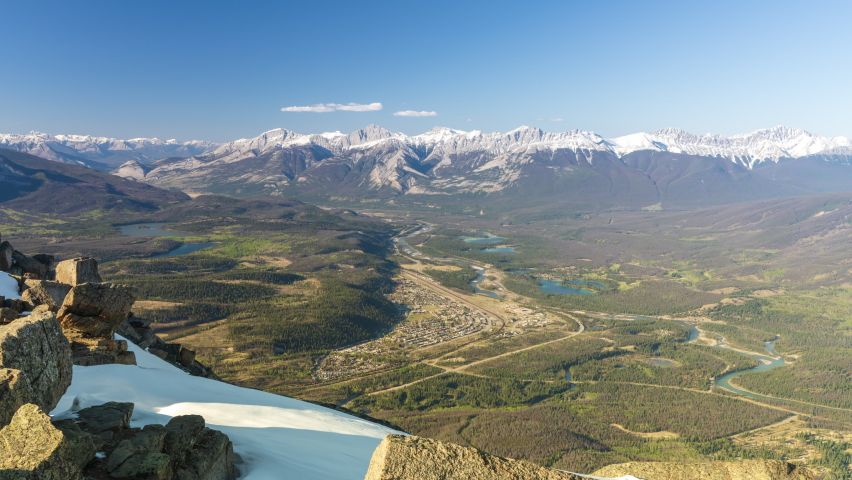 Aerial view Town of Jasper in spring time, Rocky Mountains in the backgrounds. Jasper National Park, Canadian Rockies, Alberta, Canada. Time-lapse.