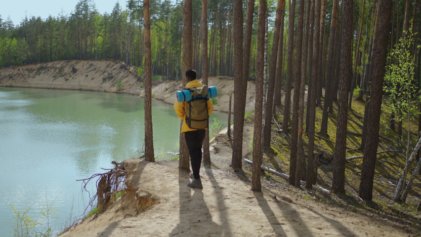Back view of one black man looking on mountain and lake. Slow motion