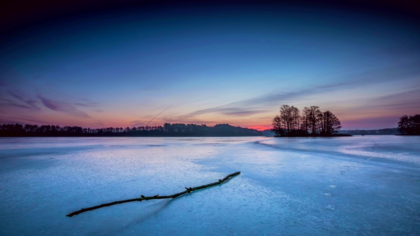 Sunrise over frozen lake in colorful 4k time lapse. 