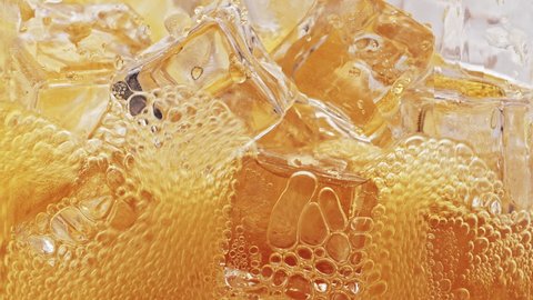 Pour orange flavored soft drinks into a glass with ice.