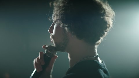 CU Portrait of young Caucasian male comedian performing his stand-up monologue on a stage of a small venue. Shot with ARRI Alexa Mini LF with 2x anamorphic lens