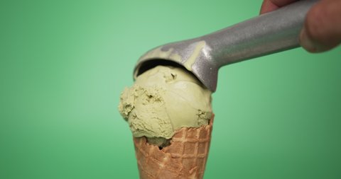Hands scoop ice cream Green tea cones on green background, Closeup Front view Food concept.