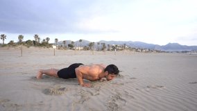 Man doing functional floor exercises in the sand on the beach