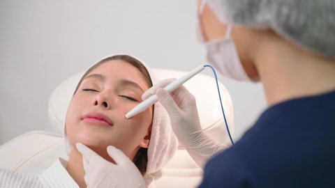 Beauty clinic - Professional cosmetologist performs DermaPen procedure in cosmetology clinic. Beauty concept. Face cosmetic procedure. body business concept.