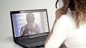 Telemedicine. A woman sitting in front of a laptop in her apartment consults with her doctor via the Internet. Online exchange of experience between two doctors.