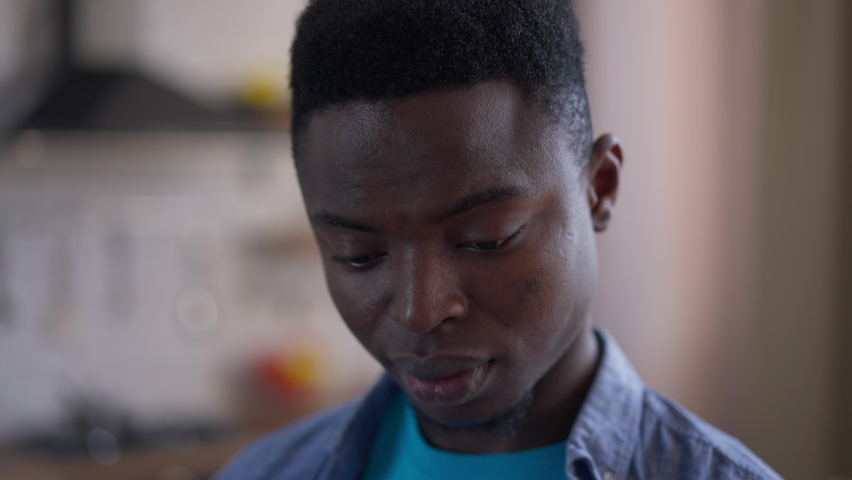 Headshot of young burnt out African American man rubbing eyes looking at camera standing in home office indoors. Portrait of sad desperate handsome millennial exhausted of remote working