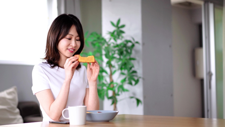 Young woman eating breakfast at home