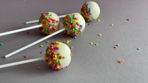 Delicious dessert with milk chocolate and biscuit inside, decorated with multi-colored confectionery. Rainbow bubbles desert. Cake pop