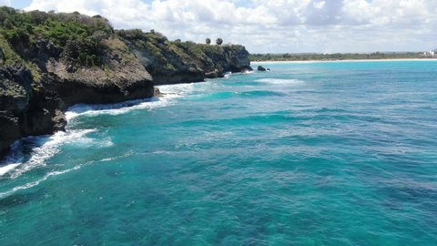 Flying along the rocky shore, blue water foaming, vacation in Dominican Republic