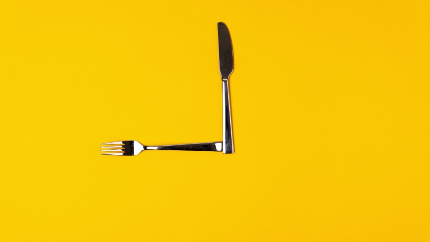 Time to eat, fork knife, alarm clock on yellow background. Stop motion animation, top view Royalty-Free Stock Footage #1073242991