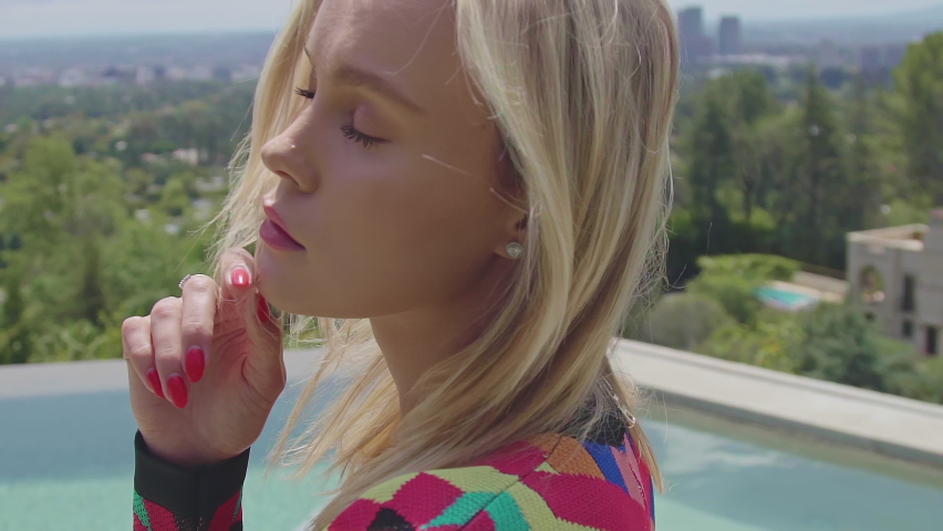 Closeup face of beautiful blonde girl. Young beautiful blonde model in a trendy dress in the luxury place. 4K